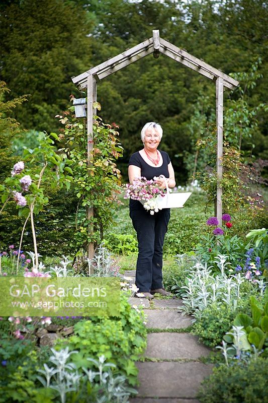 Cherry tree garden owner, June Skinner holds a trug of Aquilegia