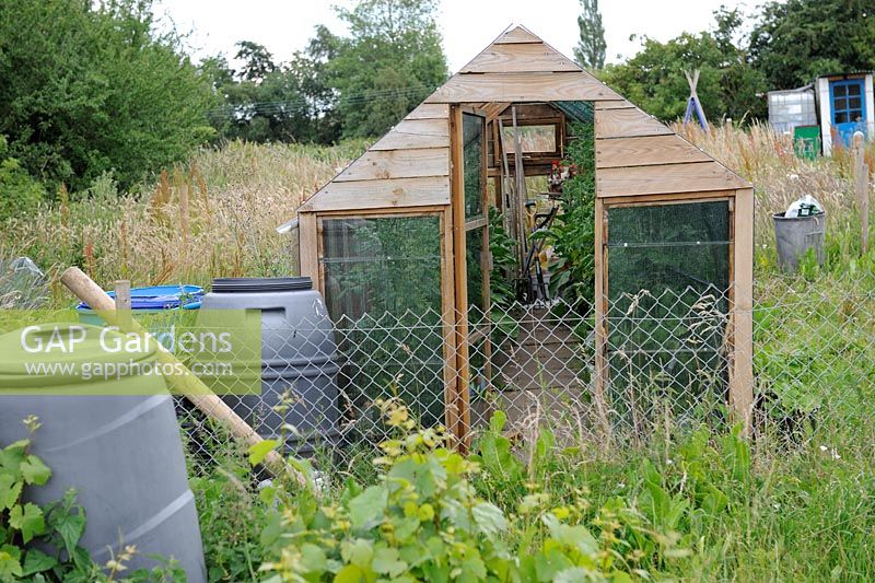 Home made greenhouse in overgrown corner of allotment, Norfolk, England, July