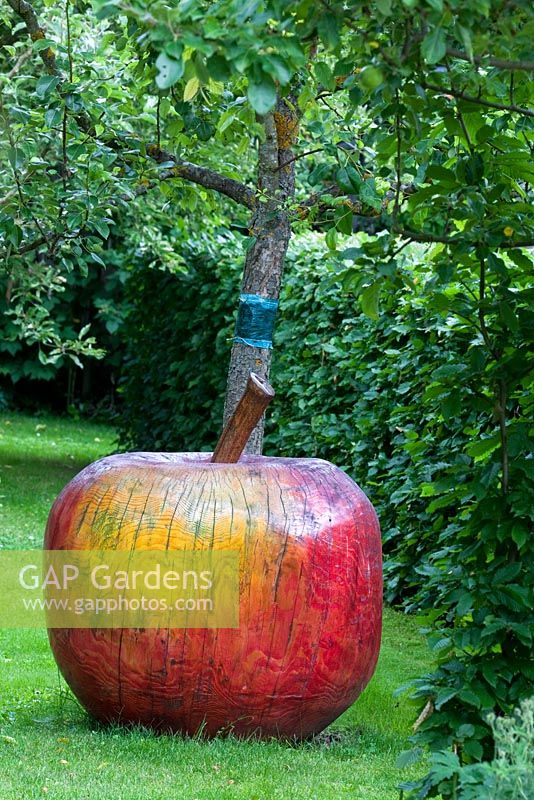 Wooden apple sculpture in the orchard