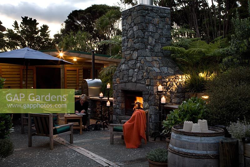 Exterior fireplace and entertaining area. Laurus - Bay trees and Cyathea dealbata - Tree Ferns. New Zealand
