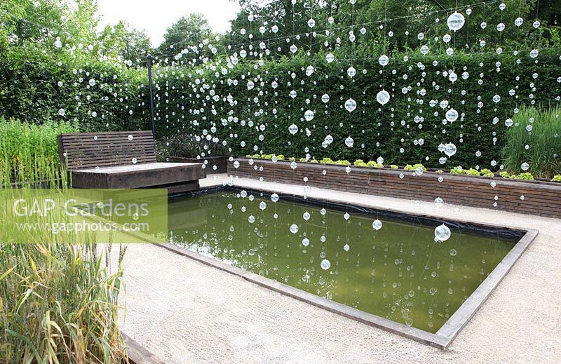 Decorations hanging over rectangular pond - The 'Exuberant pollen' garden - Festival International des Jardins de Chaumont sur Loire 2011