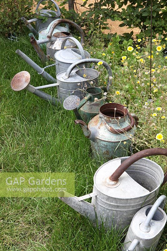 Line of metal watering cans in the 'Sculptillonnage' garden - Festival International des Jardins de Chaumont sur Loire, France 2011
