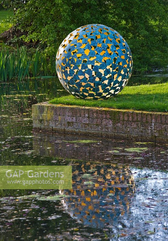Sculpture on lawn next to pond
