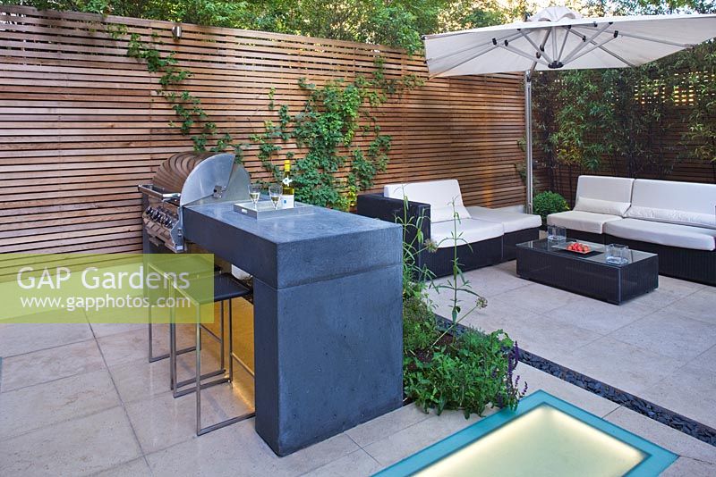 Modern garden with barbecue, built in lighting and dining area 
