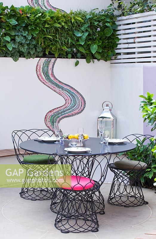 Small patio garden with dining area and mosaic by Celia Gregory, London. 
