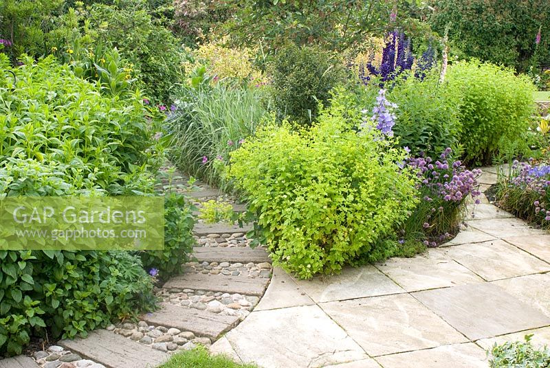 Paths made from concrete sleepers and cobbles with adjacent cottage borders 