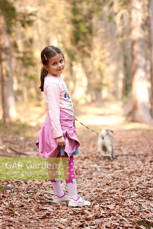 Girl in pink on a walk with the dog