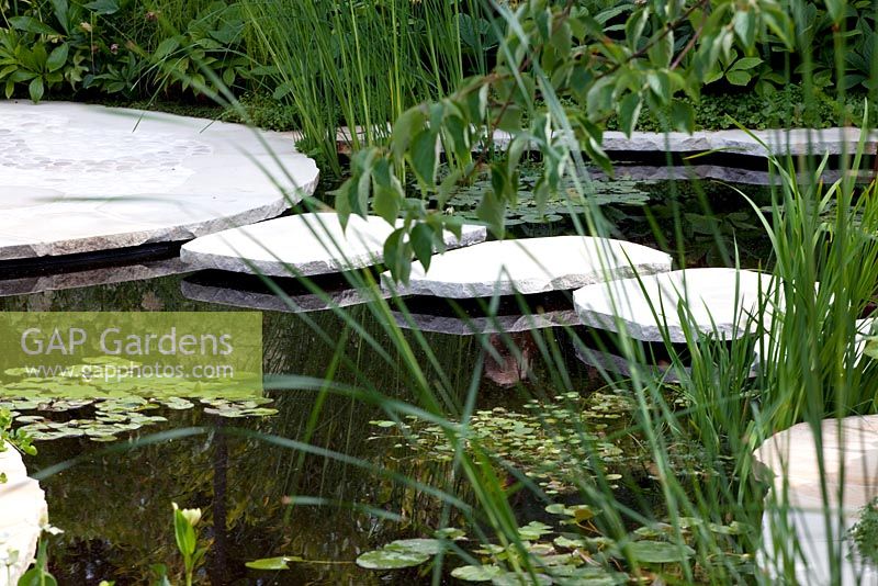 White stepping stone bridge over pond in the 'Trailfinders Australian Garden presented by Fleming's Nurseries' RHS Chelsea Flower Show 2011 
