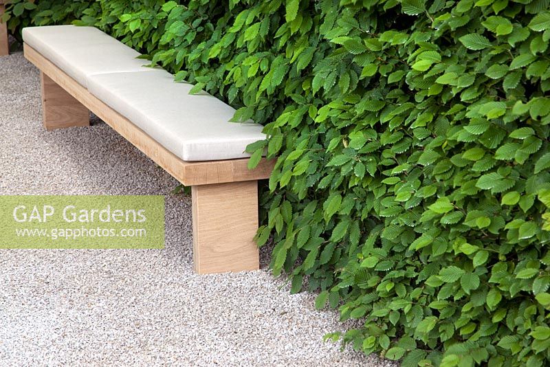 Upholstered wooden bench on gravel path - The Laurent-Perrier Garden - Nature and Human Intervention - Gold Medal Winner, RHS Chelsea Flower Show 2011