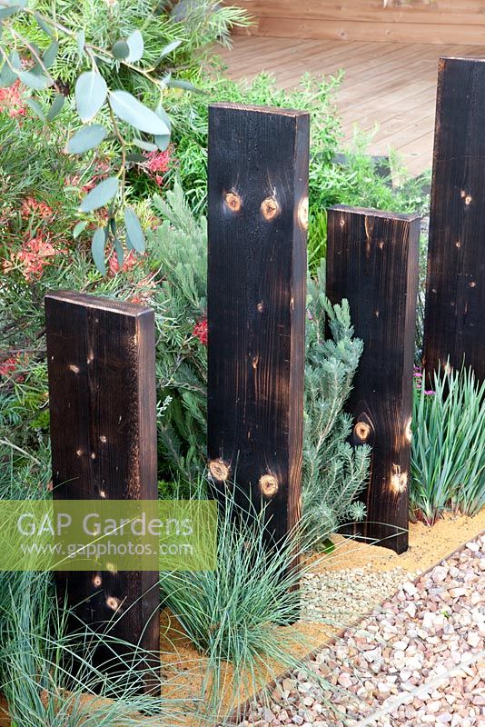 Recycled timber used as an informal fence with mediterranean style planting - 'A Monaco Garden' - Gold Medal Winner, RHS Chelsea Flower Show 2011 
