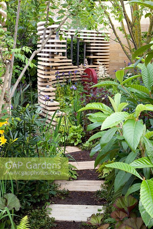 Concrete path and  tropical planting in 'The Bradstone Fusion Garden' - Silver Gilt Medal Winner, RHS Chelsea Flower Show 2011 
