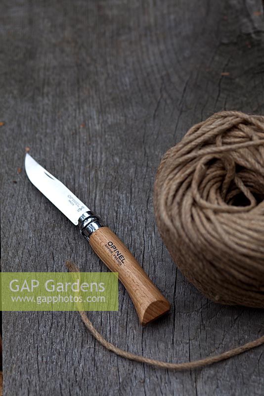 Wooden garden handled knife with ball of string on bench