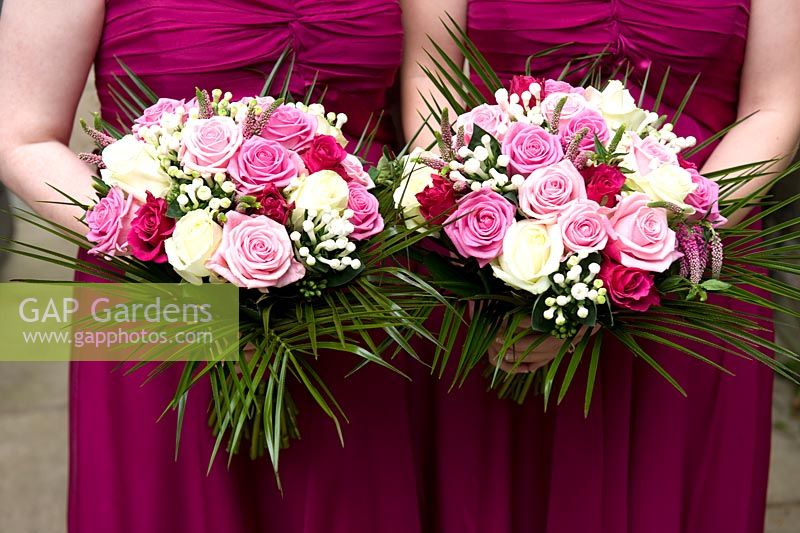 Bridesmaids holding wedding bouquets of pink and white roses