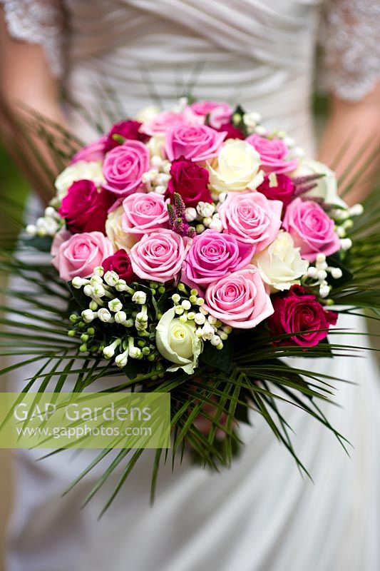 Bride holding a wedding bouquet of pink and white Roses