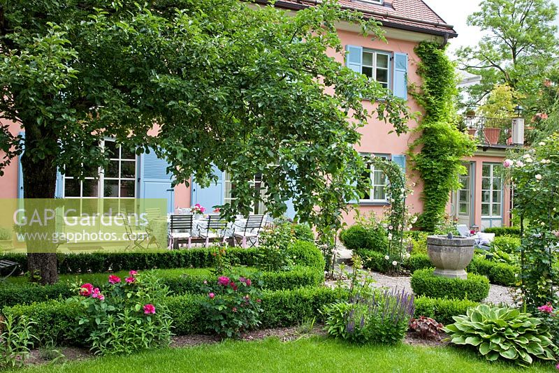 Country house and terrace with old Apple tree, Buxus - Box edged pathways, perennials and a water basin focal point  - Handbag Garde, Freising, Germany
 