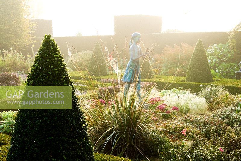 The Formal Garden, with knot garden made of box and berberis, with a statue of a girl holding the lamp of wisdom by Nathan David, and surrounded by tall yew hedges