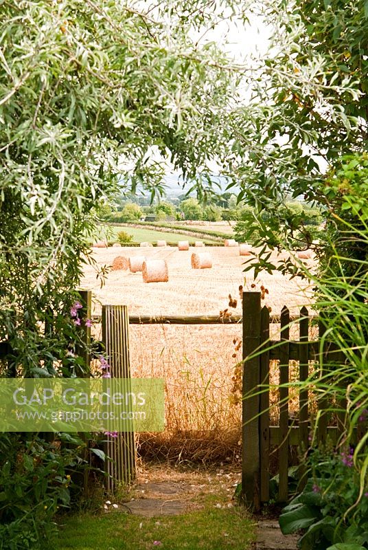Gate to adjoining farmland, with views of bales of straw