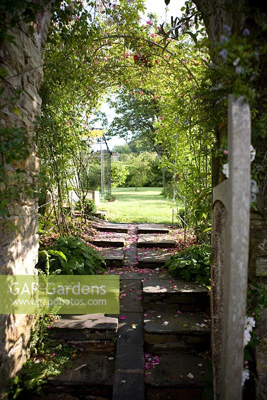 Rose arch way over gateway and path between garden rooms 