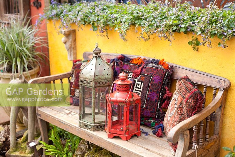 Wooden bench with decorative lamps and pillows at Chelsea Flower Show 2011