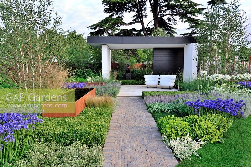 Modernist planting set in blocks with rusting water troughs around an open plan pavilion with lacquered wall