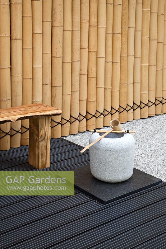 Seating area and bamboo fence in a Japanese themed garden   - 'Less and More' garden - RHS Hampton Court Flower Show 2011