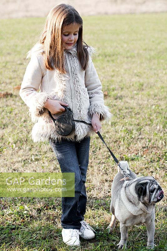 Girl on a walk with her pet Pug