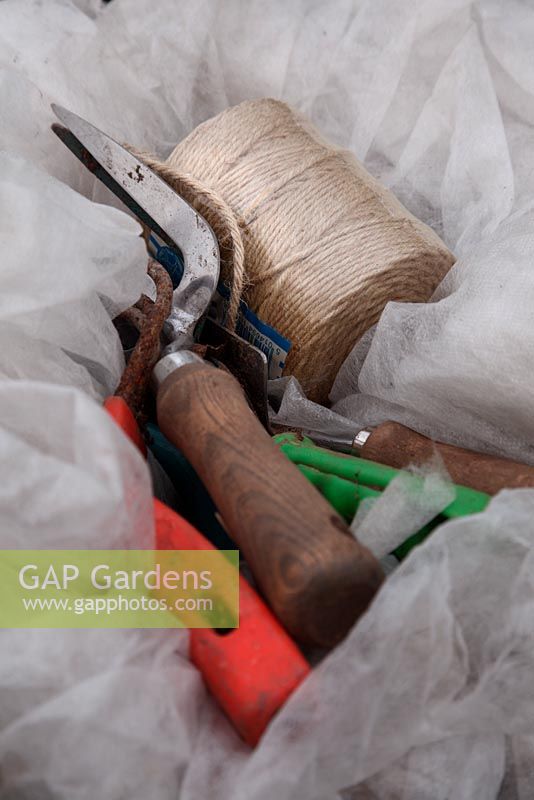 Gardening hand tools - fork, trowel, string on horticultural fleece