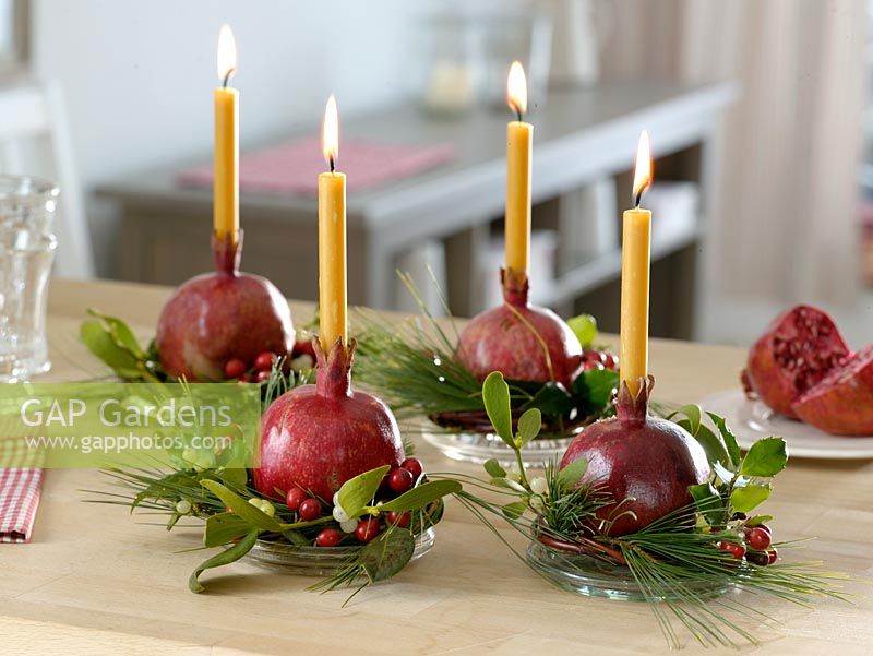 Candle holders made from pomegranates and mistletoe