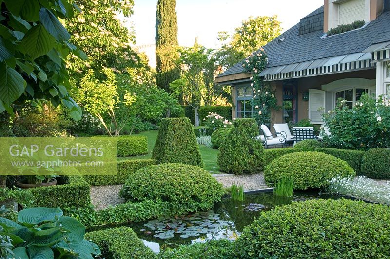 Formal style Mediterranean garden with clipped hedges and pond - Madrid, Spain 