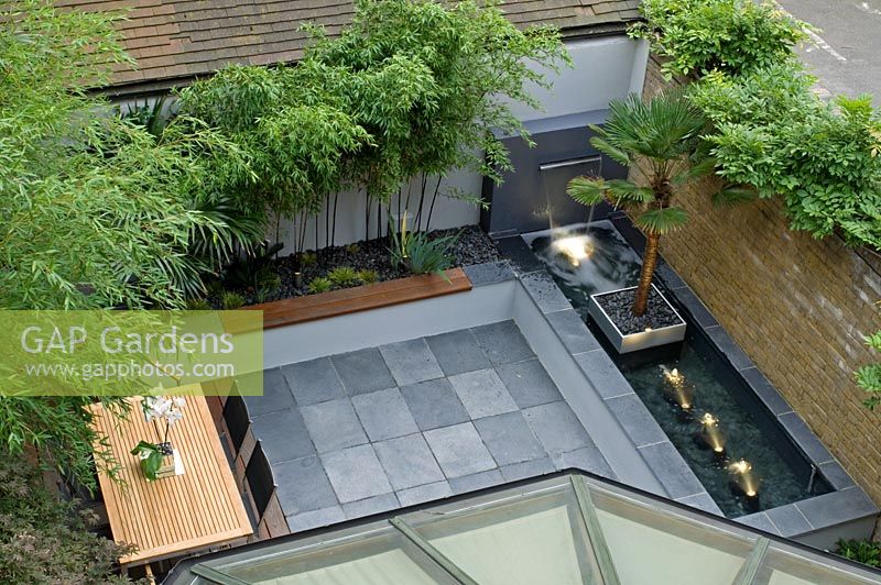 Small urban garden with seating area and water feature