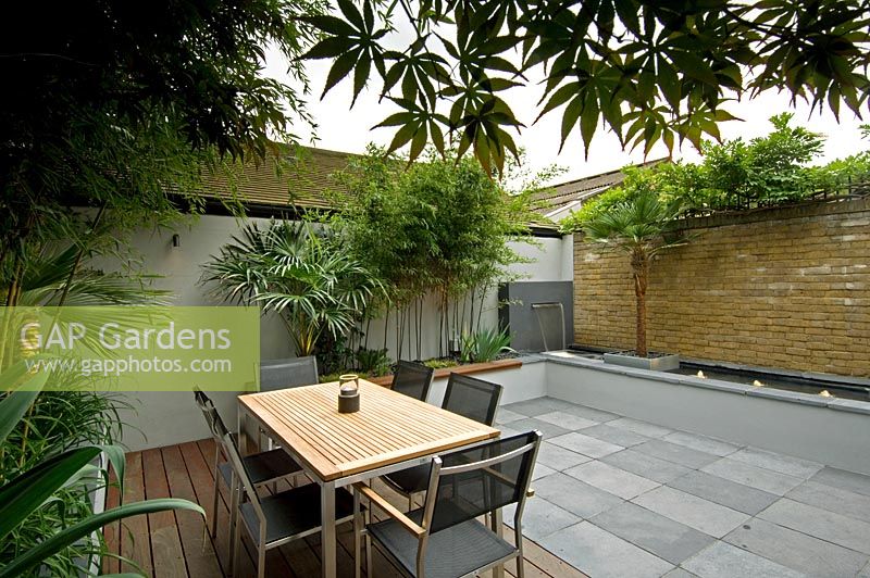 Small urban garden with seating area and water feature, London