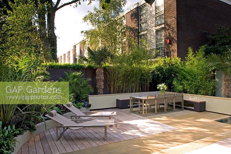 Small urban garden with decked relaxing area and loungers, London
