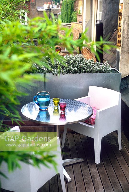 Contemporary roof garden with patio furniture, bamboo screen and metal trough container -Islington, London, England