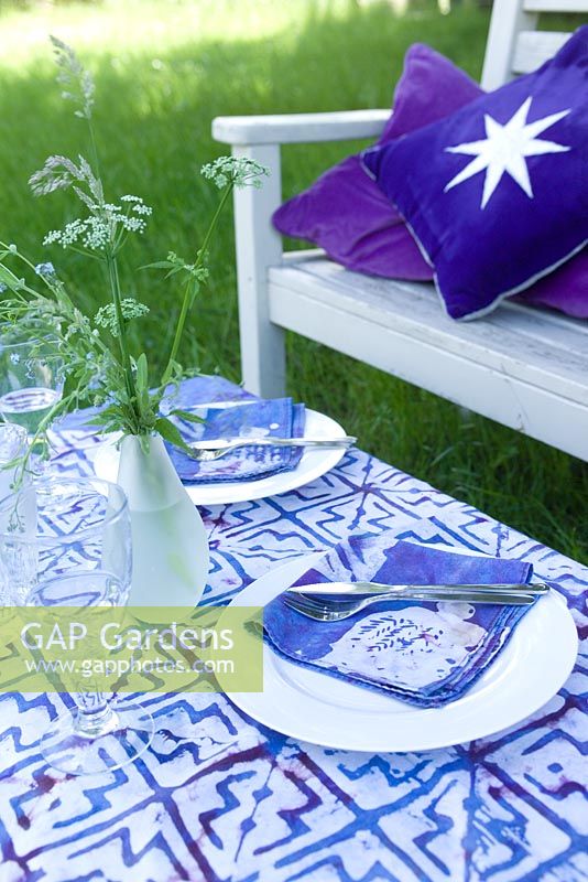 Table set with cloth, cutlery and wildflower posie for al fresco summer meal