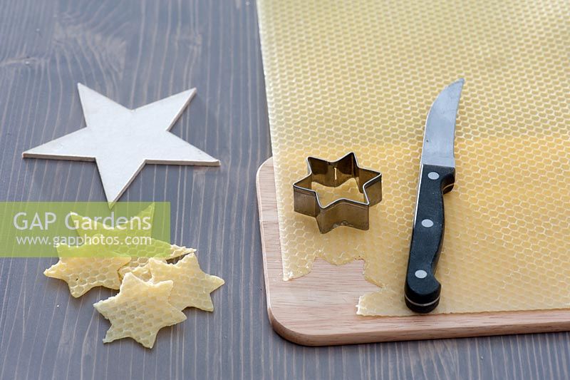 Making decorations - Stars cut out of beeswax. Wood and star cookie cutter, knife and wooden board