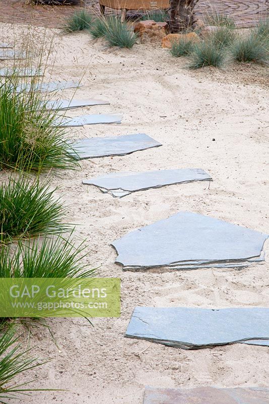 Stepping stone path through sand bordered with Festuca  and Deschampsia cespitosa - Tropical Touch