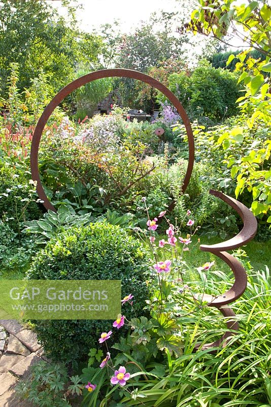 Metal ring and spiral used as decoration in flowerbed - Marx Garden