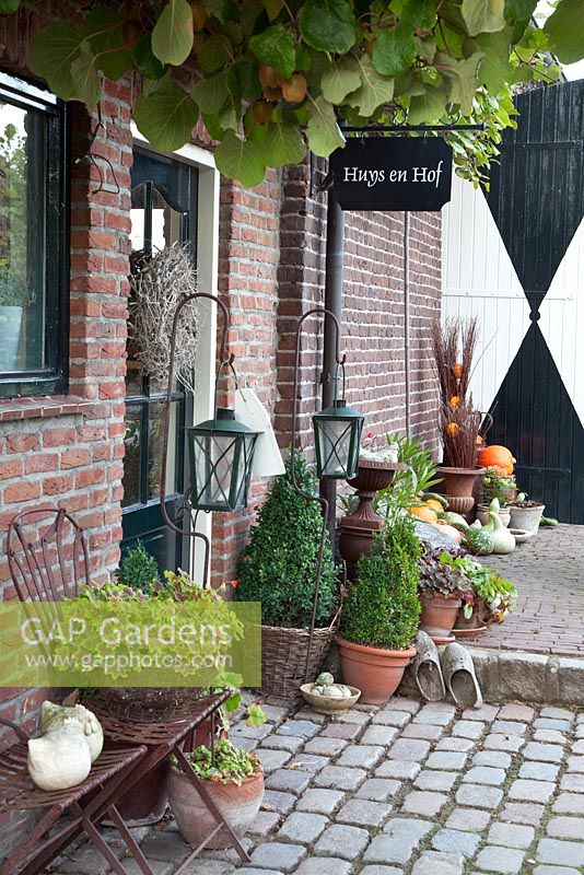 Entrance to house with containers and pots on cobbles - Huys en Hof 