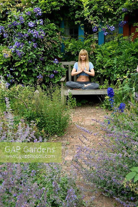 Woman practising yoga on garden bench