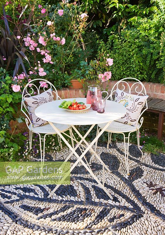 Patio with pebble mosaic, table and chairs