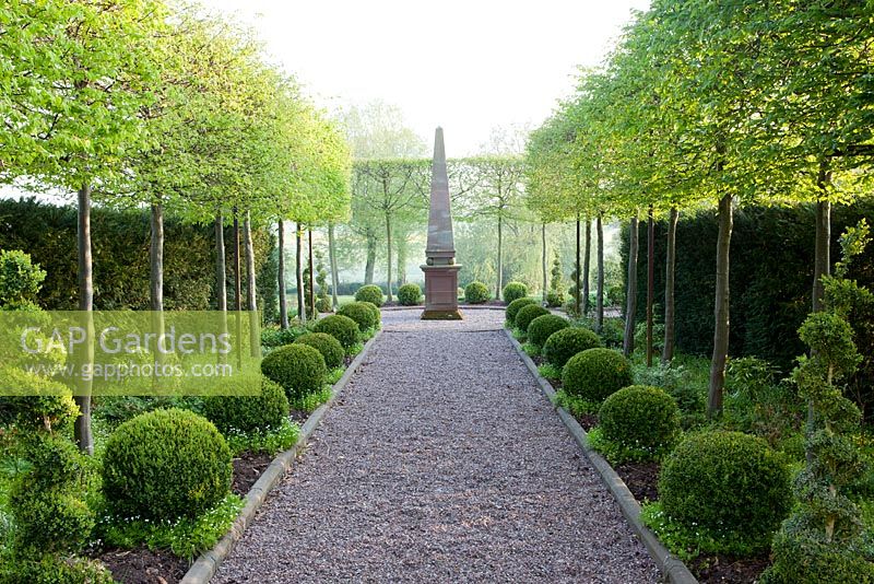 Mitton Manor in Staffordshire. Clipped hornbeams and box sphere topiary, with obelisk focal point