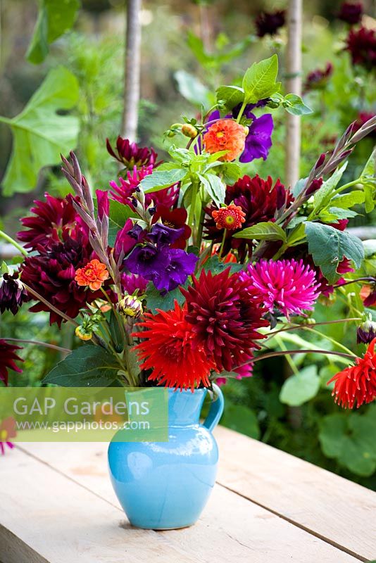 Gladiolus and dahlias in a turquoise vase