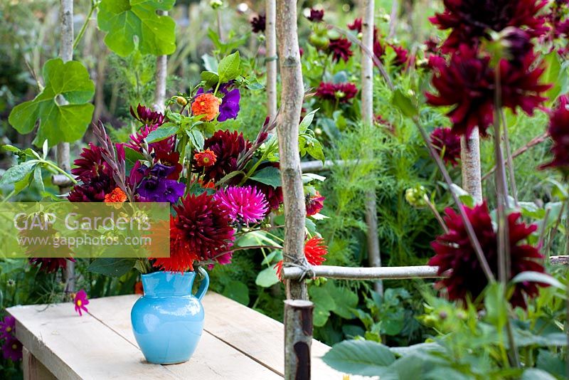 Gladiolus and dahlias in a turquoise vase
