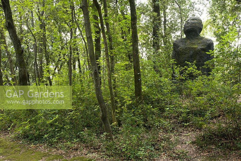 Large figurative sculpture in woodland garden 