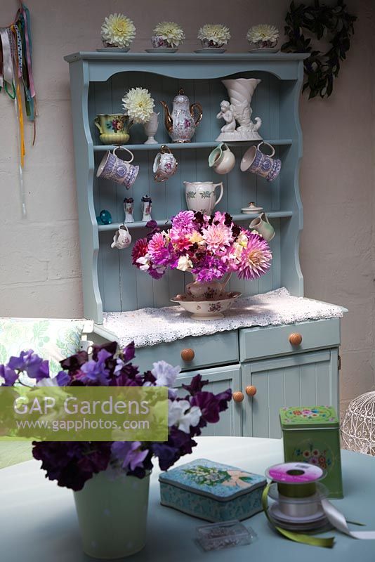 Old dresser in the flower studio with collection of vintage vases, Dahlia arrangement, freshly picked Sweet Peas, ribbons and pins - Green and Gorgeous