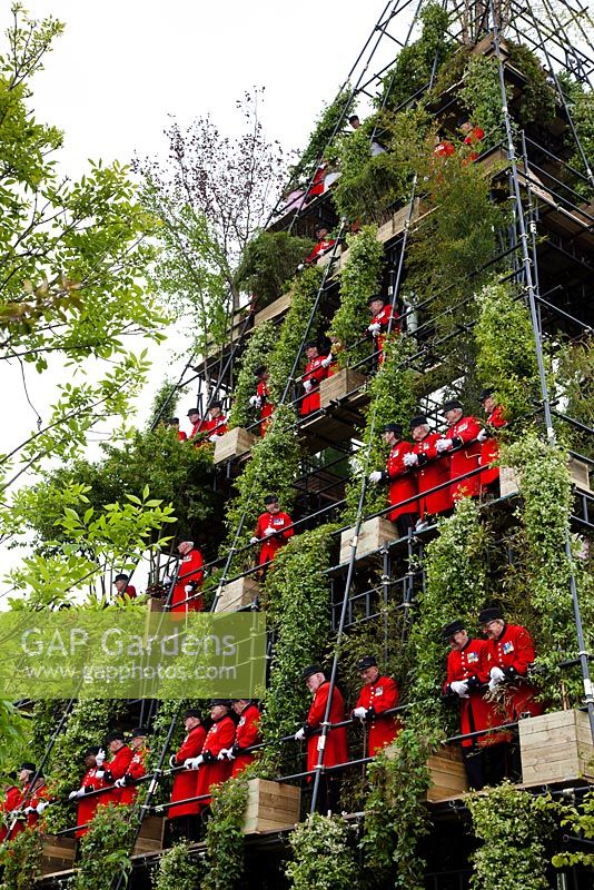 The Westland Magical Garden, a multi-level pyramid, seen here with the Chelsea Pensioners on board. Sponsor - Westland Horticulture.