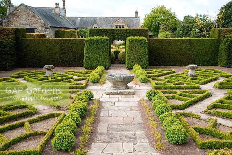 Stone basin in the Fancy Garden includes a gazebo, from which to gaze upon the garden, and a pattern made from box based on a Tudor rose pattern - Herterton House, Hartington, Northumberland, UK