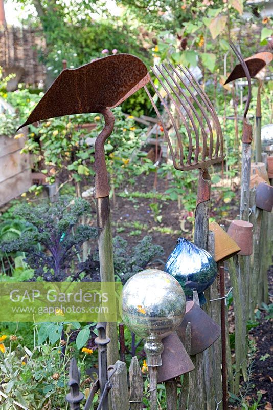Rustic fence decorated with old gardening tools and equipment