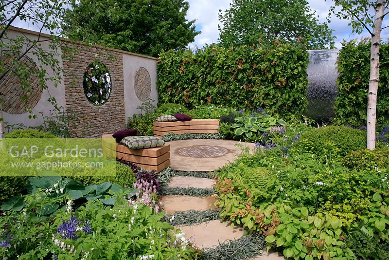 Sculptural wall with built in seats framing a pool and stepping stones curving through birch trees.A Place to Reflect. Graduate Gardeners Ltd. Malvern Spring Show 2012. Gold medal and Best Show Garden. 