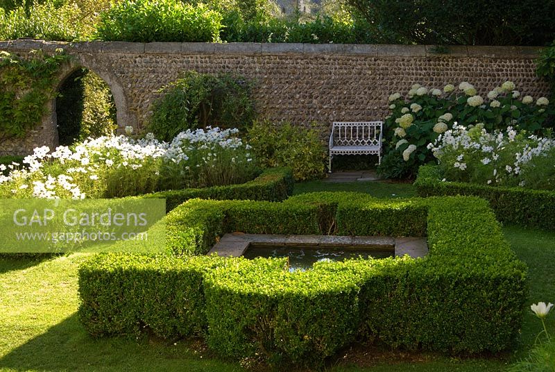 Garden outside the Fitzalan Chapel, planted with white flowers set in box edged beds and a central reflecting pool. 